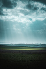 Dramatic spring nature with dramatic clouds and light rays and green countryside nature