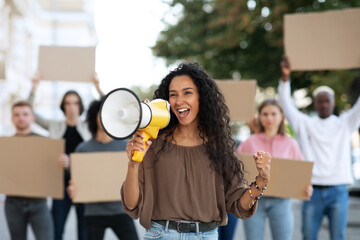 Multiracial protestors striking on the street, holding megaphone and placards