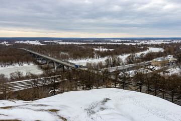 Road bridge over the frozen russian river 