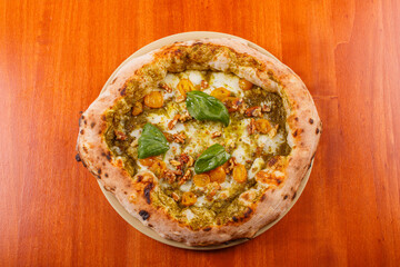 Pizza napoletana con pesto genovese, pomodorino giallo, mozzarella, noci e basilico fresco