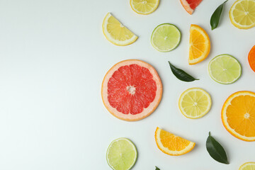Fototapeta na wymiar Fresh citrus slices on white background, space for text