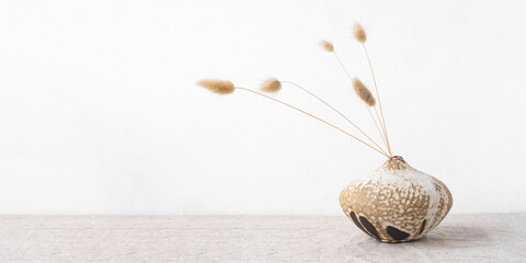Handmade ceramics in the style of wabi sabi. Brown clay vase with an abstract pattern.