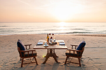 Romantic breakfast on beach. Breakfast table with island sunrise