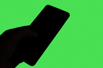 Business Man Technology Concept:Smartphone in male hand isolated on green background.