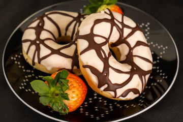 donuts and fresh strawberries on black background