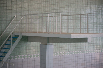 close up of empty springboard in swimming pool. covered with ceramic tiles. High quality photo