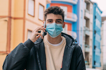 young man with mask and mobile phone on the street