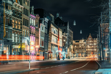 Night city view of Amsterdam city, street with illuminated buildings of old European city, Netherlands.