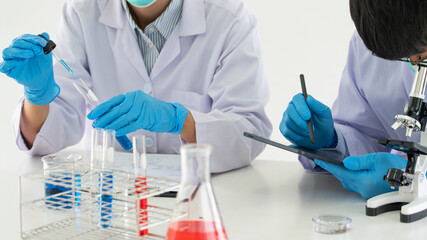 Team of Medical Research Scientists or researcher in lab coat testing their experimental in Modern laboratory.