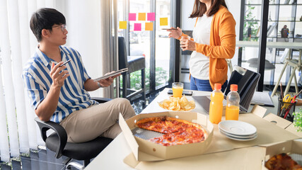 Business team workers discussing work and prepare pizza and potato chips to sharing meal at lunch break for good relations in office.