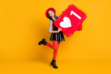 Full length body size view of pretty trendy cheerful girl holding in hands big like board having fun isolated over bright yellow color background