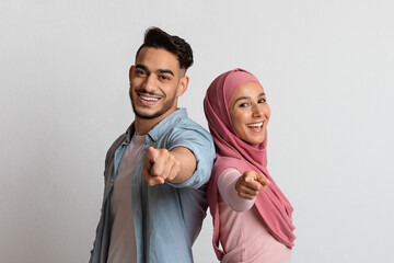 You Are Next. Happy muslim couple pointing at camera and smiling
