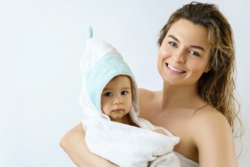 Young and happy mother and her cute little baby after bathing