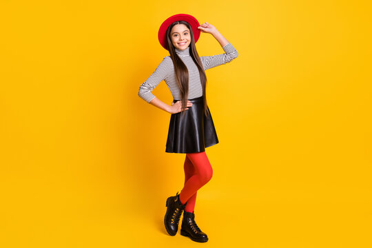 Photo of small lady posing wear striped turtleneck headwear leather skirt shoes isolated yellow color background
