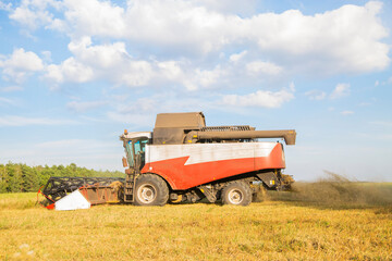 old combine harvester harvests from the field