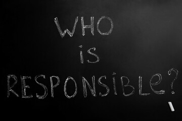 Fototapeta premium Question Who Is Responsible and chalk piece on black background