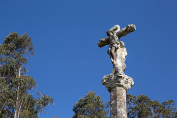 Antique carved stone cross called Cruceiro. Galicia, Spain. Low angle. Copy space