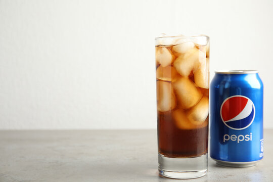 MYKOLAIV, UKRAINE - FEBRUARY 10, 2021: Glass and can of Pepsi on grey table. Space for text