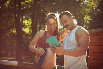 Couple standing outside and using digital tablet.