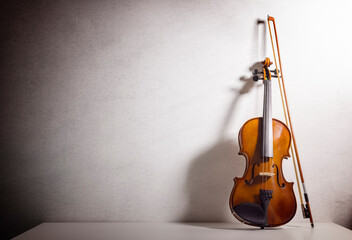 Violin leaning against a blank wall  background with copy space for music concept