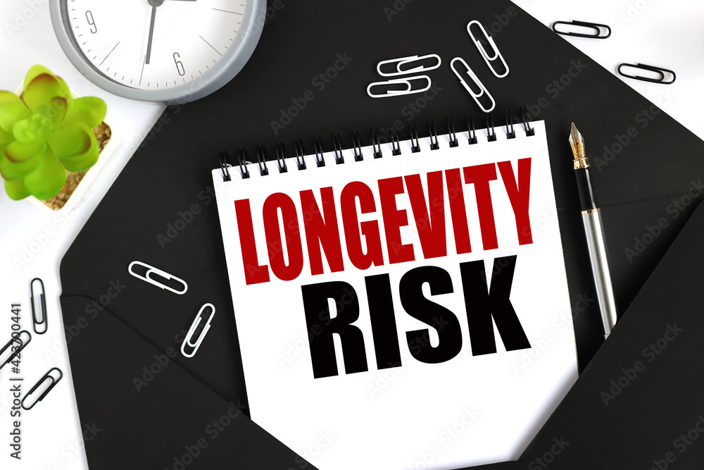 Poster longevity risk. text on a sheet of notepad on a black envelope on a light background