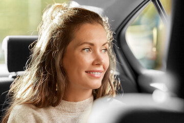 transport, vehicle and people concept - happy smiling woman or female passenger in taxi car
