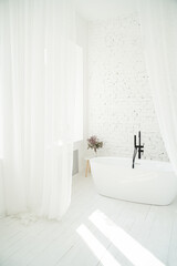 white stylish minimalistic bathroom with sheer curtains and brick wall. Sunlight from the window. Vertical composition. Interior architectural design. Pure home space. Scandinavian chic style. 