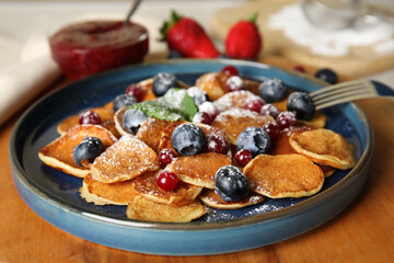 Cereal pancakes with berries on wooden board, closeup