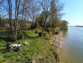 Groupe d'amis pique-niquant au bord de la Garonne, Gironde