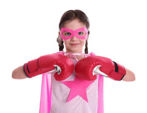 Cute little girl in superhero suit and boxing gloves on white background