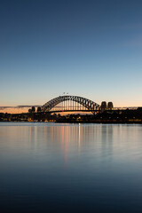 Dawn view of Sydney Harbour Bridge with clear sky.