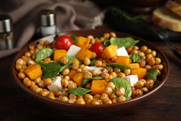 Delicious fresh chickpea salad on wooden table