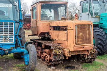 Fototapeta na wymiar Abandoned farm equipment. Old tractors are rusty and broken.