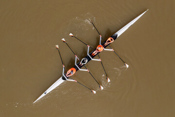 Sport Canoe with a team of four people rowing on tranquil water, Aerial view. © STOCKSTUDIO