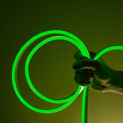 Flexible green led tape neon in hand on black background