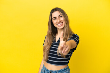 Young caucasian woman isolated on yellow background showing and lifting a finger