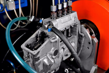 A fuel pump for a diesel engine after repair on an adjustment stand in a workshop, fuel pump repair, adjustment of fuel pump nozzles on a bench, fuel stand for pump adjustment, overhaul,