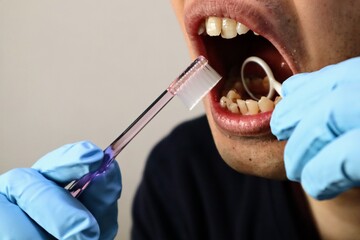 汚れを鏡で見ながら歯磨きをする人物
