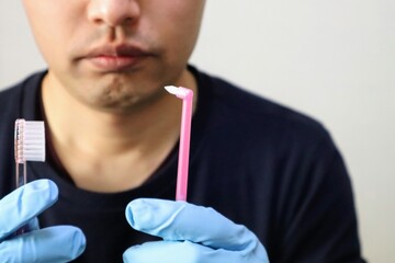 歯のケア用品を持つ人物