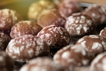 Cracked chocolate cookies with icing sugar on a pan