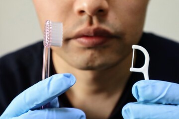 歯のケア用品を持つ人物