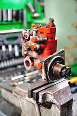 locksmith repairing an old diesel pump, a fuel pump clamped in a vise for disassembly close-up