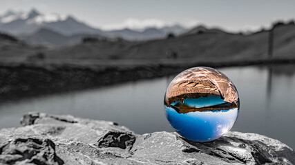 Crystal ball alpine landscape shot with black and white background outside the sphere at the famous Asitz summit, Leogang, Salzburg, Austria
