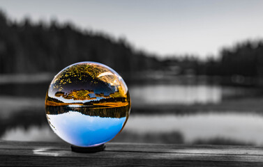 Crystal ball alpine landscape shot with black and white background outside the sphere at the famous Grosser Arbersee, Bayerisch Eisenstein, Bavarian forest, Bavaria, Germany