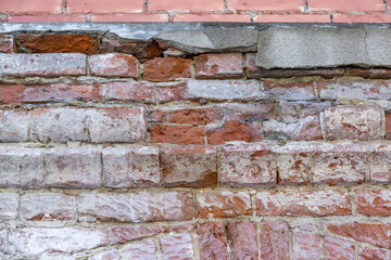 Embossed textured surface of an old wall made of facade bricks and cement