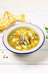 Canned fish soup in a bowl on wooden background. Space for text.