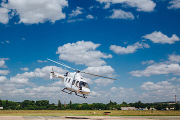 A white helicopter takes off from the runway
