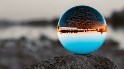Crystal ball landscape shot with black and white background outside the sphere and reflections in the river danube near Metten, Bavaria, Germany