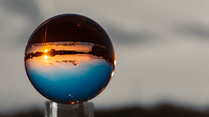 Crystal ball sunset landscape shot with black and white background outside the sphere and...