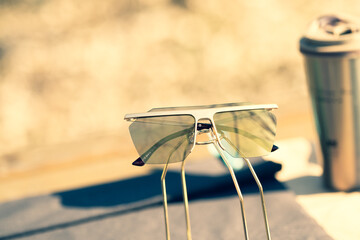 Futuristic Oversized sunglasses model with golden lenses shoot outside in a summer day closeup . Selective focus. High quality photo